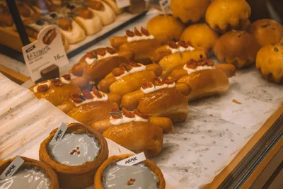 Una exhibición de panes y pasteles frescos en un entorno de panadería, destacando la variedad y la textura.